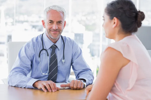 Attractive doctor sitting in front of patient