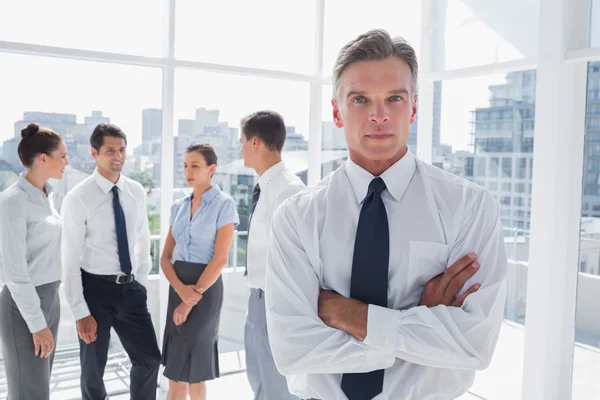 Boss with arms folded standing in a modern office