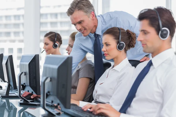 Smiling manager helping call centre agent