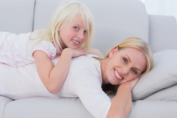Mother and daughter lying on couch