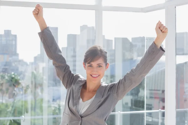 Excited businesswoman cheering and smiling