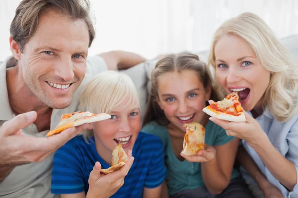 Smiling family eating pizza