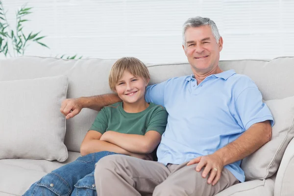Young boy sitting on the couch with grandfather