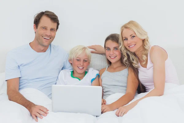 Smiling family using a laptop together