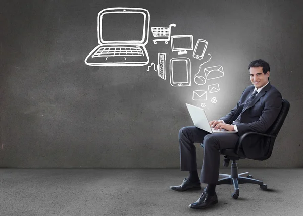Businessman typing on his laptop with media device graphics comi