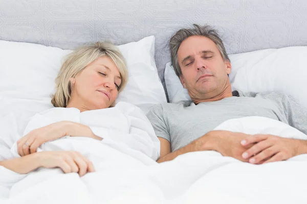 Couple sleeping peacefully in their bed