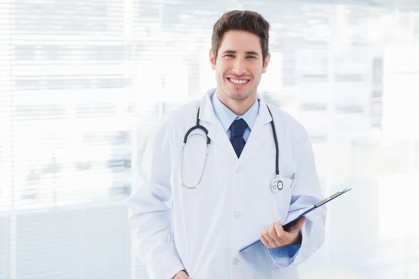 Smiling doctor holding files and looking at camera