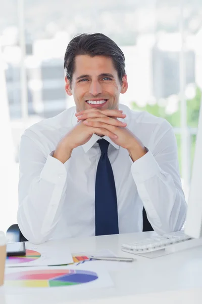 Smiling businessman posing crossing fingers