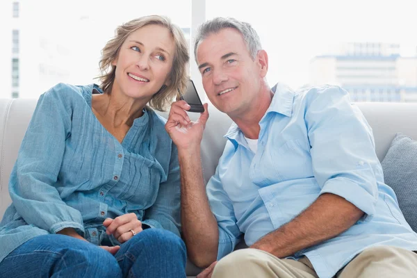 Cheerful couple listening to mobile phone together