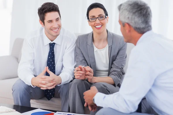 Happy business people talking and working together on sofa