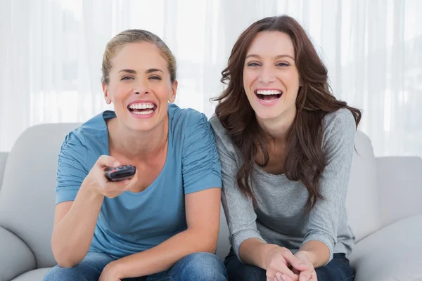 Laughing women watching television