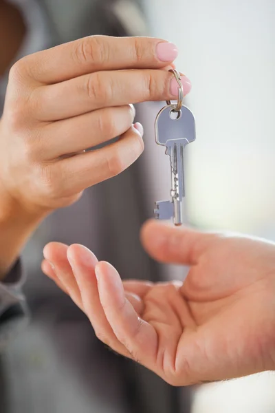 Estate agent giving house key to customer