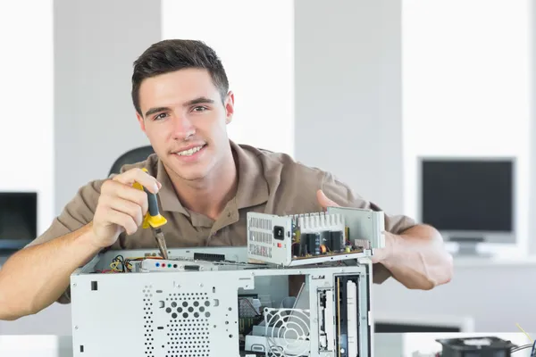 Handsome cheerful computer engineer repairing open computer