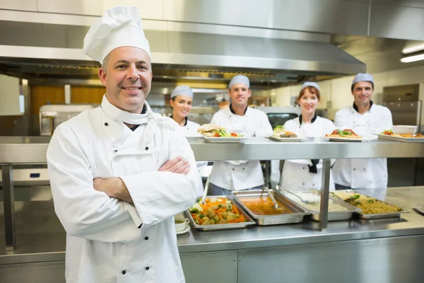 Proud mature head chef posing in a modern kitchen