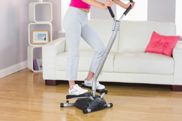 Sporty woman training on step machine