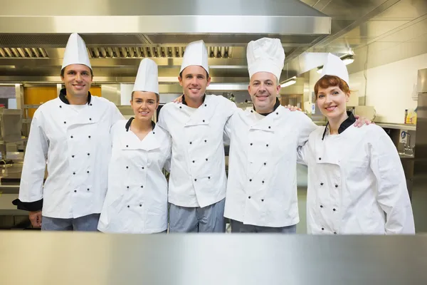 Five happy chefs smiling at the camera