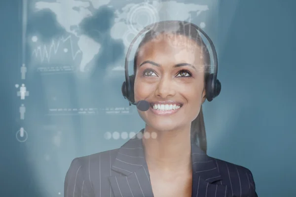 Happy pretty businesswoman looking at futuristic interface hologram