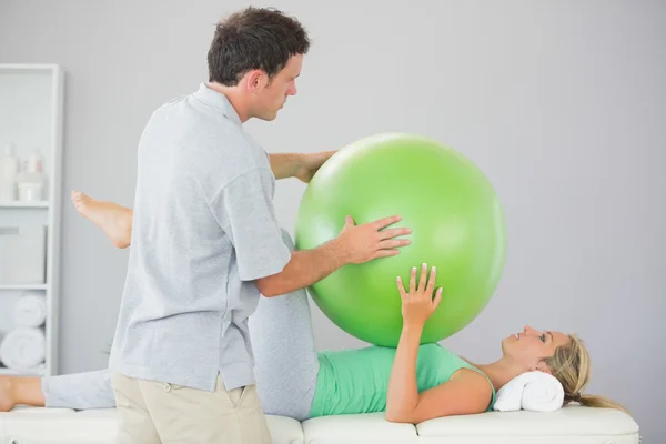 Patient training with exercise ball and physiotherapist