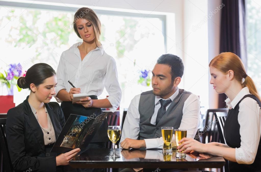 Three business people ordering dinner from waitress — Stock Photo