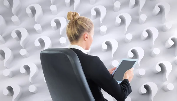 Businesswoman sitting on swivel chair with tablet