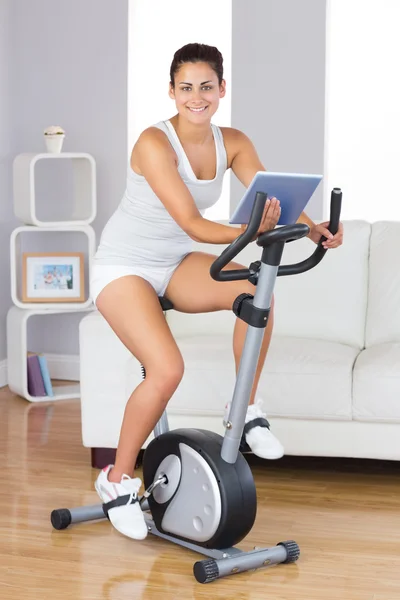 Happy training woman using an exercise bike