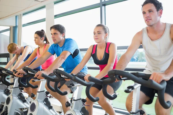 Determined people working out at spinning class