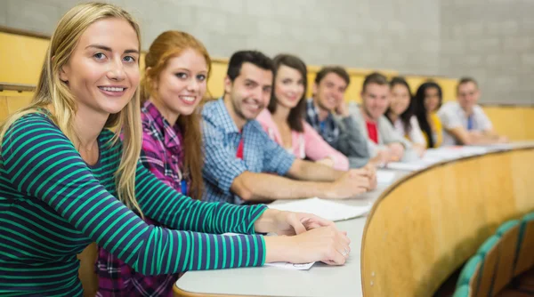Smiling students sitting in a row at the lecture hall