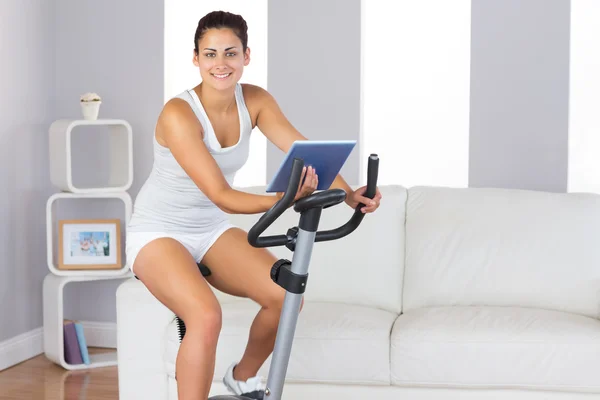 Cheerful sporty woman training on an exercise bike