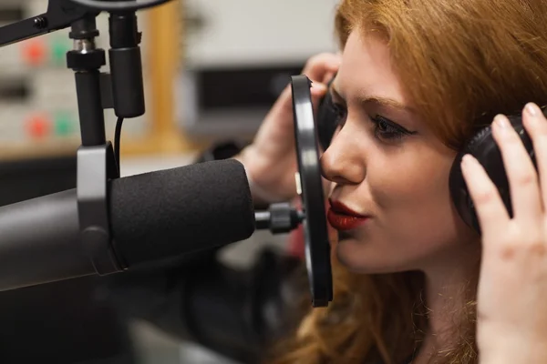 Focused beautiful singer recording a song