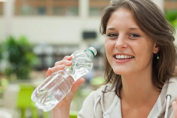Close-up portrait of a young woman drinking water
