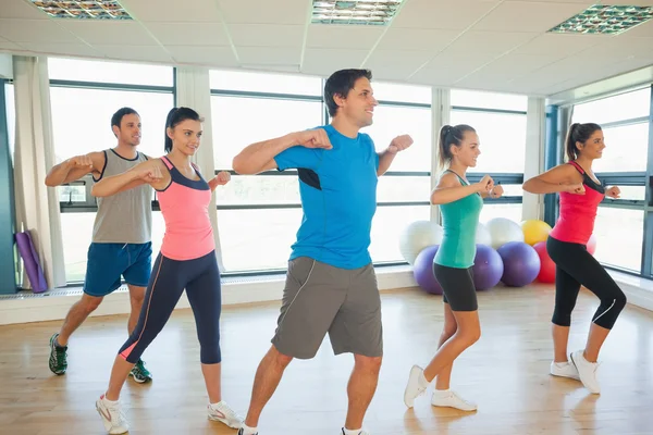 Sporty people doing power fitness exercise at yoga class