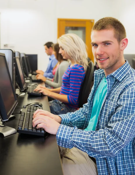 Teacher showing something on screen to student in computer room