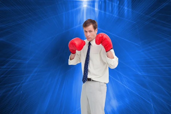 Composite image of businessman with his boxing gloves ready to f