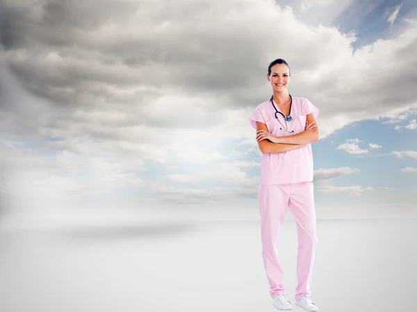 Beautiful nurse standing in front of the camera with folded arms