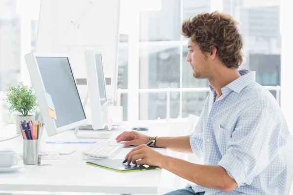 Male artist drawing something on graphic tablet with pen