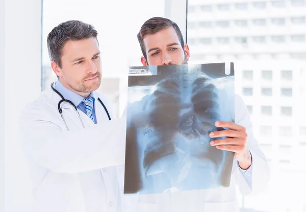 Male doctors examining x-ray in medical office