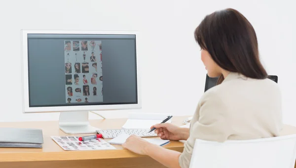 Rear view of a artist at desk with computer in office