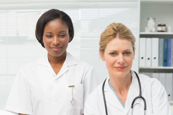 Happy doctor and nurse smiling at camera