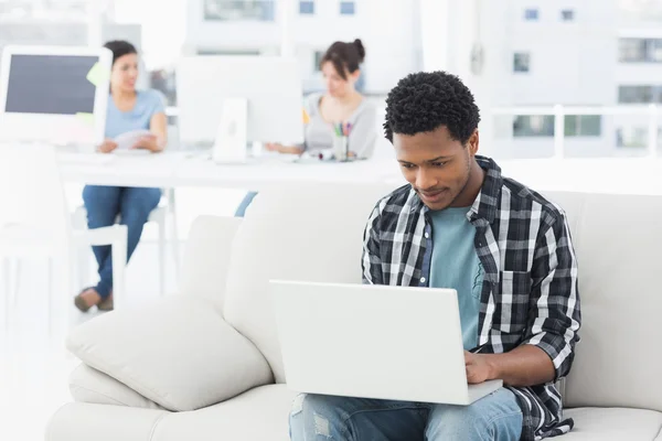 Man using laptop with colleagues at creative office