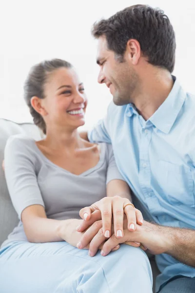 Excited couple looking at each other on the couch