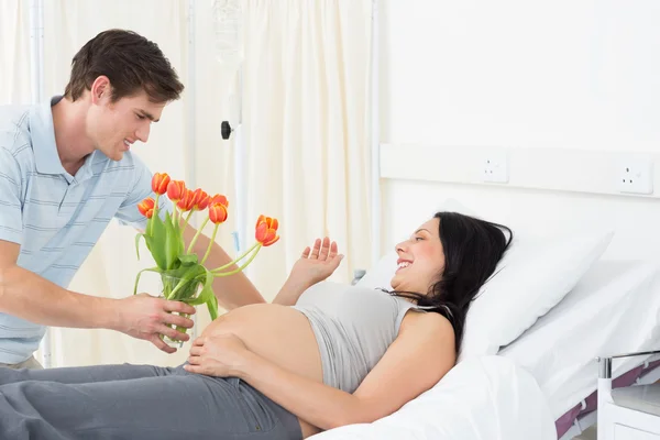 Man offering flowers to pregnant woman