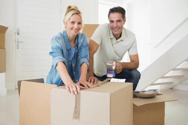 Couple packing boxes in a new house