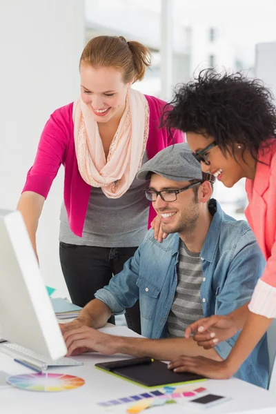 Smiling artists working on computer at office