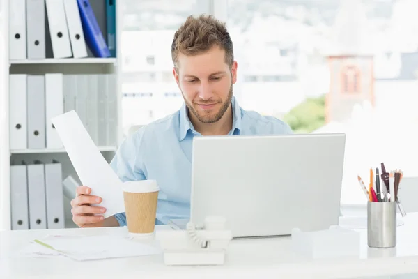 Happy man working at his desk on laptop