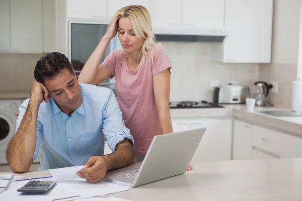 Unhappy couple with bills and laptop