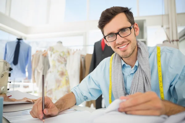 Smiling male fashion designer working on his designs