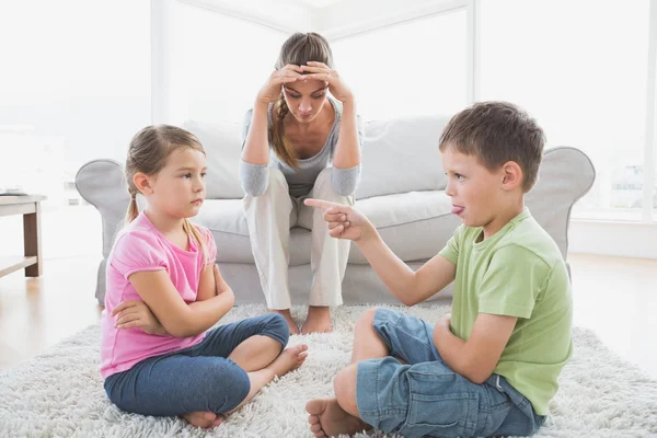 Fed up mother listening to her young children argue