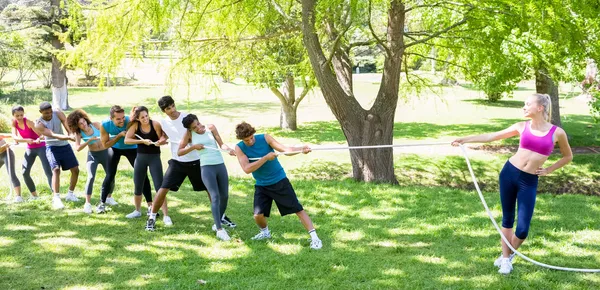 Woman playing tug of war with friends