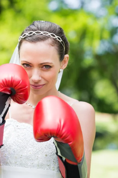 Woman in wedding dress with boxing gloves