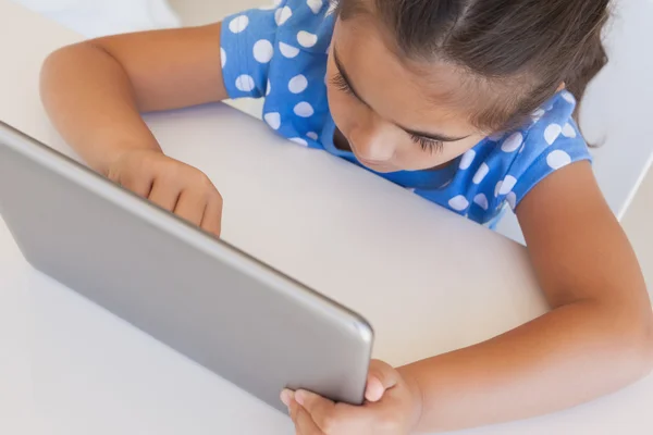 Girl using digital tablet on table